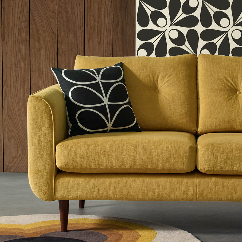 Black stem Orla Kiely cushion on a yellow sofa 